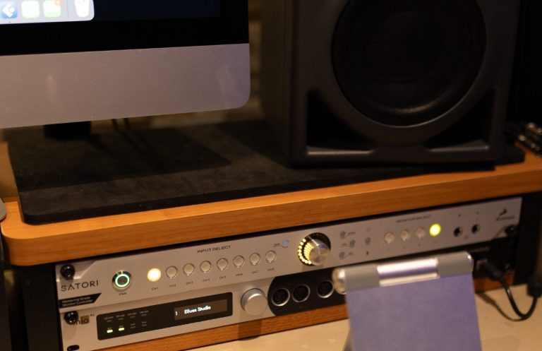 Tonstudio mit blauen Wänden, Akustikpaneelen und Mikrofonen in der Ecke.