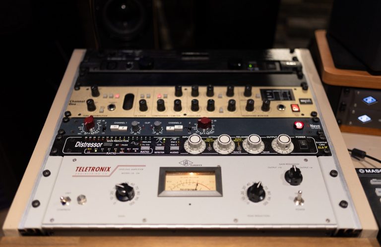 Ein Musikproduktionsgerät mit Reglern, Tasten und einem analogen VU-Meter.